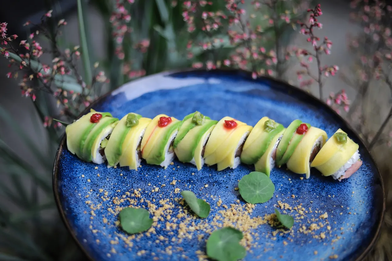 Zielone rolki sushi na niebieskim talerzu