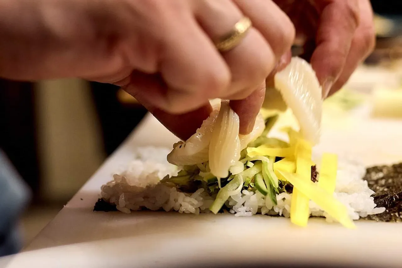 Układanie dodatków na rolce sushi